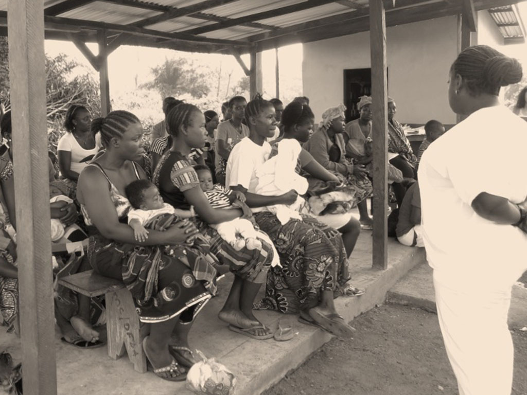 Community health session with mothers and infants gathered under a shelter in WHO's Africa region