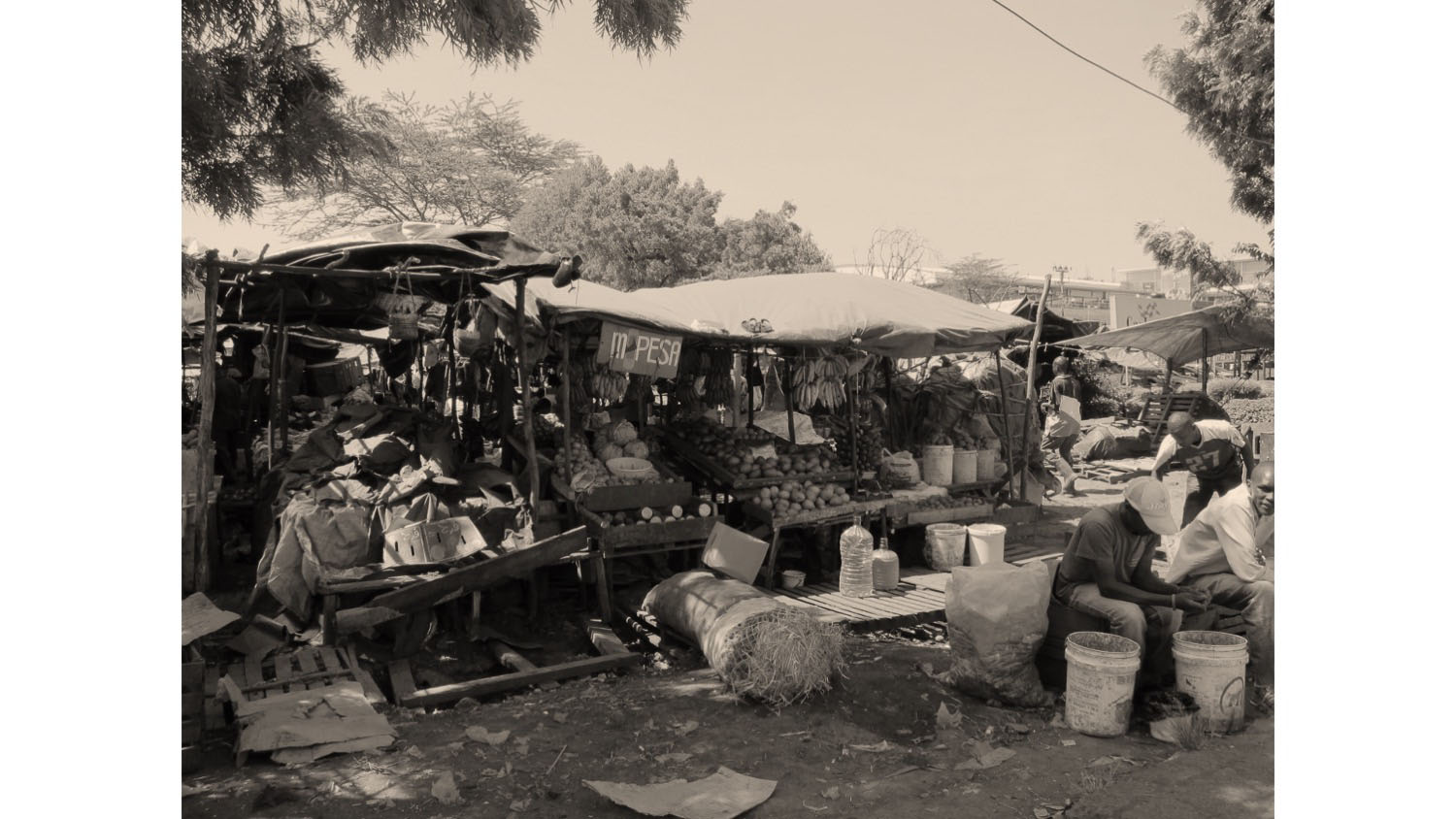 Outdoor market stalls with vendors and produce, representing micro-businesses